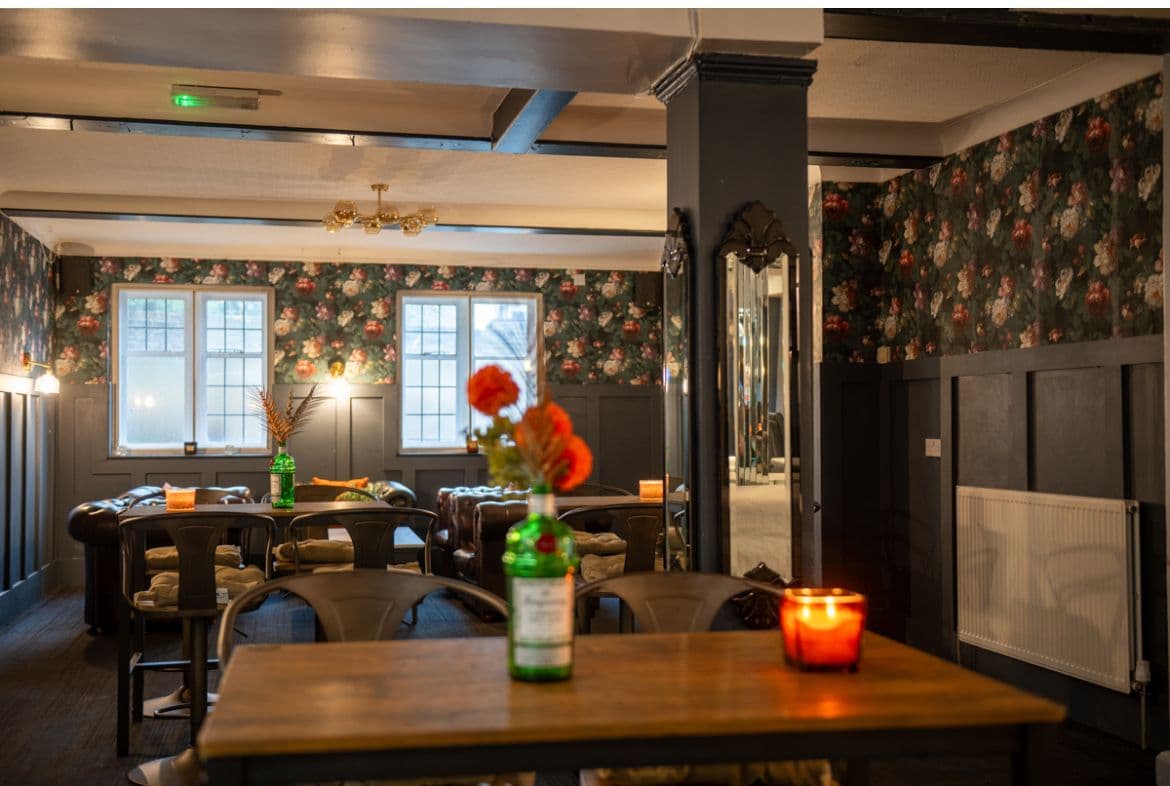 Lounge with Chesterfield sofas and floral wallpaper