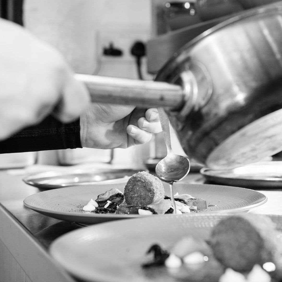 Chef finishing plates at the pass